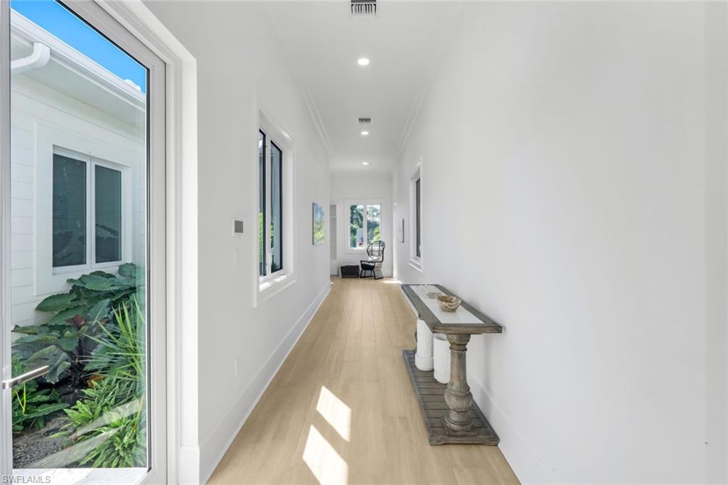 3136 Ravenna Avenue Naples, FL 34120 - Photo 26 of 50 Corridor featuring light wood-type flooring, recessed lighting, and crown molding