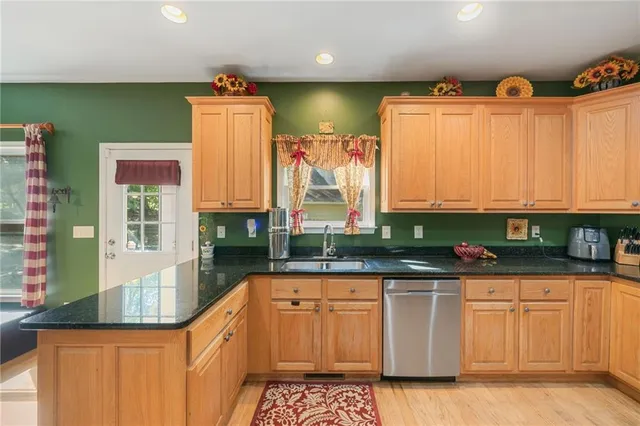a kitchen with stainless steel appliances granite countertop a sink a stove and cabinets