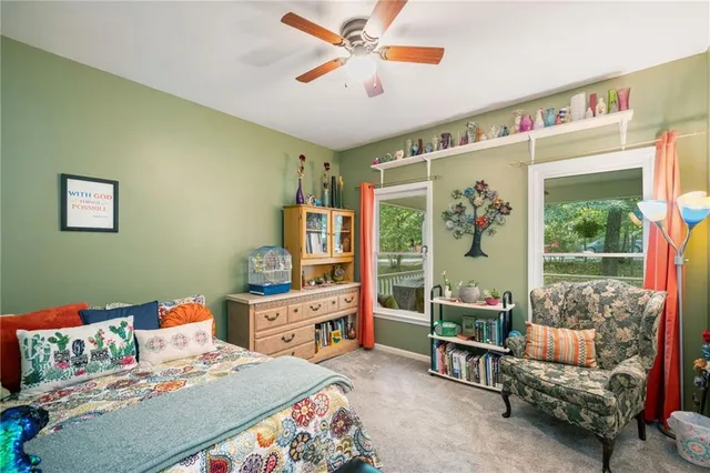 a bedroom with a bed a large window and a couch