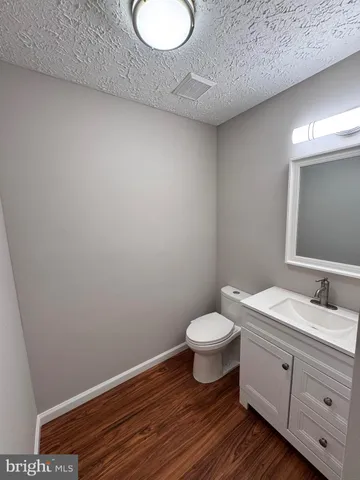 a bathroom with a granite countertop toilet and sink
