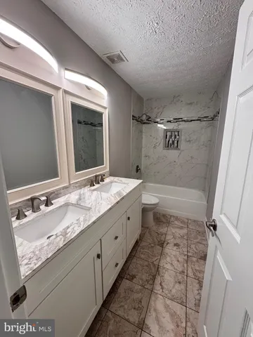 a bathroom with a granite countertop sink mirror and shower