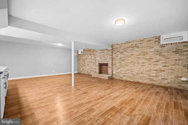 a view of empty room with wooden floor and fireplace