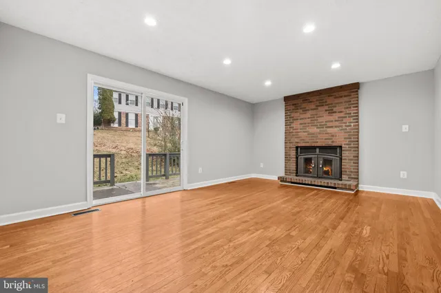 an empty room with wooden floor and a fireplace