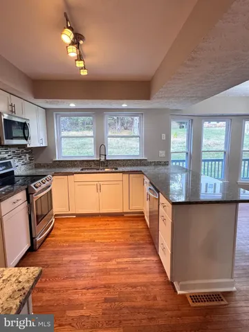 a large kitchen with cabinets and wooden floor