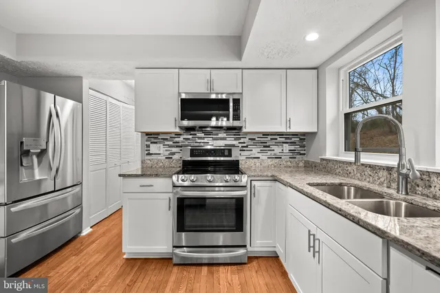 a kitchen with stainless steel appliances granite countertop a stove a sink and a refrigerator
