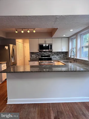 a kitchen with stainless steel appliances granite countertop a sink and cabinets