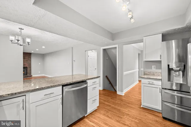 a kitchen with granite countertop cabinets stainless steel appliances and a counter space