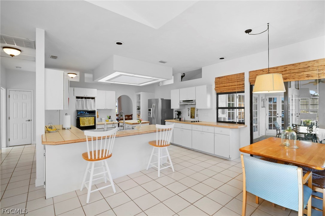 11772 Mahogany Run Fort Myers, FL 33913 - Photo 21 of 50 a large white kitchen with a table and chairs