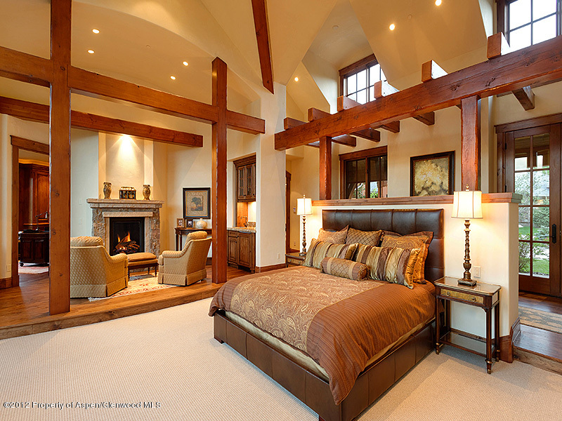360 Eagle Pines Drive Aspen, CO 81611 - Photo 19 of 40 a bedroom with a large bed and a fireplace