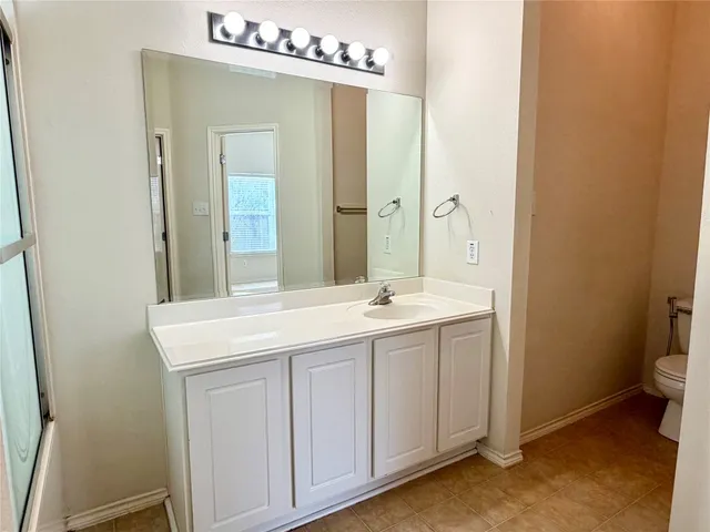 a bathroom with a sink a toilet and mirror