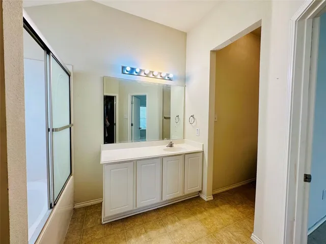 a bathroom with a sink a mirror and a shower