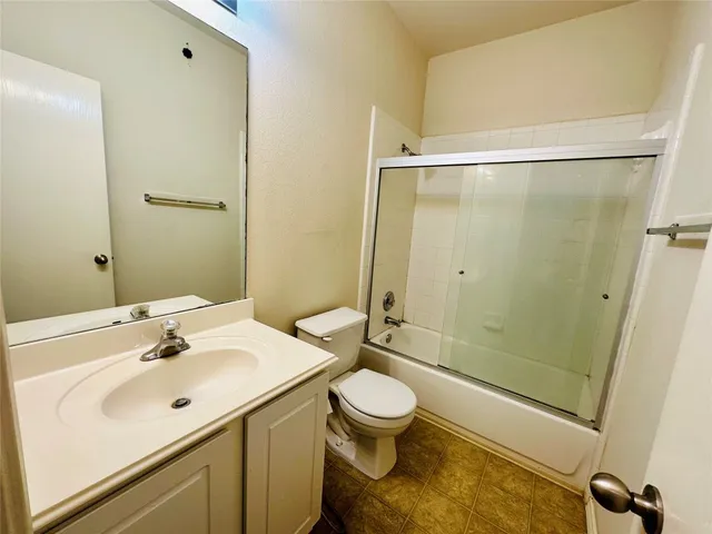 a bathroom with a sink mirror vanity and toilet