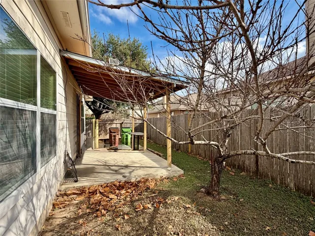 a view of a house with a large tree and wooden fence