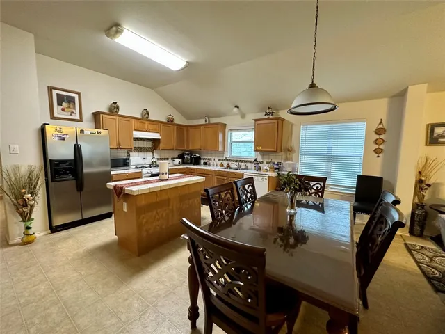 a kitchen with stainless steel appliances granite countertop a sink a stove and refrigerator