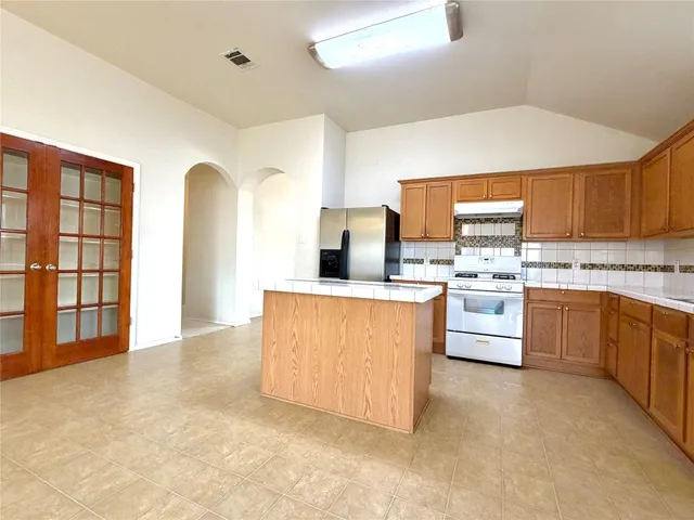 a kitchen with stainless steel appliances a stove top oven and a refrigerator