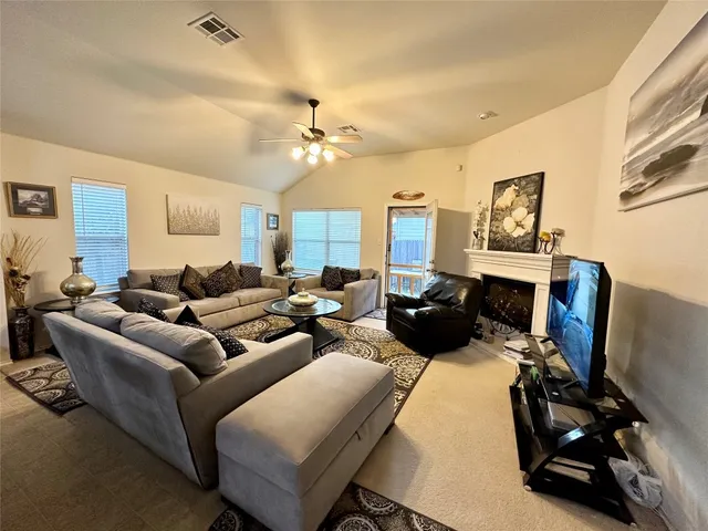 a living room with furniture a flat screen tv and a window