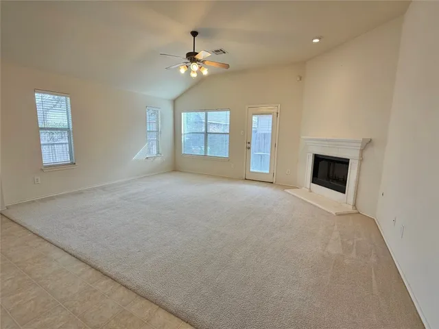 an empty room with windows and fireplace