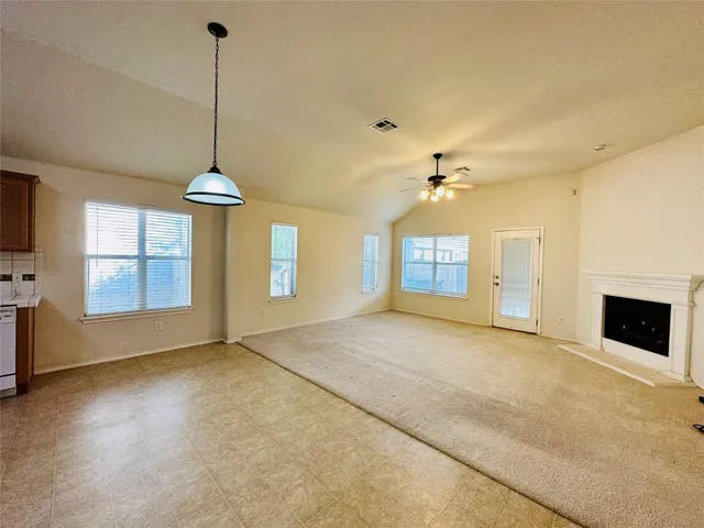 a view of an empty room with a window and fireplace