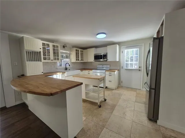 a kitchen with a table chairs refrigerator and cabinets