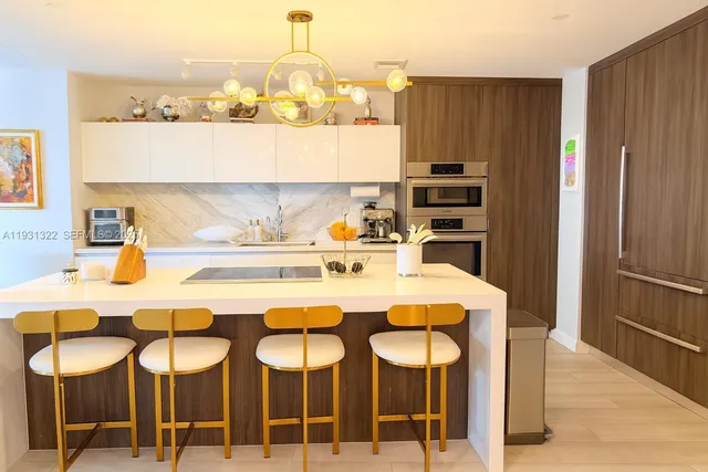 a kitchen with a table chairs refrigerator and cabinets
