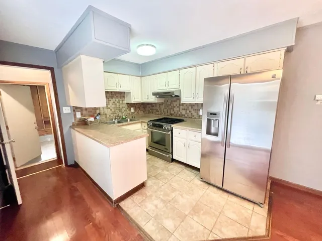a kitchen with a refrigerator a sink and a stove top oven