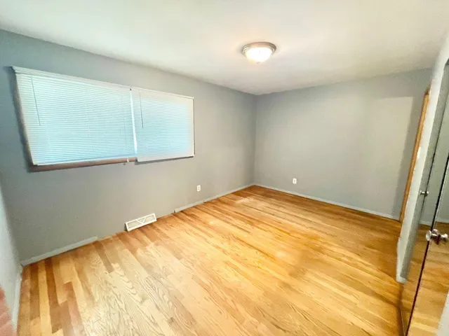 a view of empty room with wooden floor
