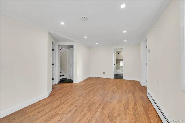 a view of a big room with wooden floor and windows