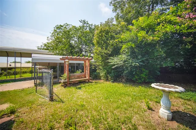 a view of a backyard with table and chairs under an umbrella