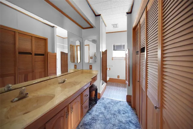 a bathroom with a granite countertop sink and a large mirror