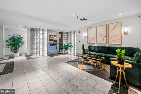 a living room with furniture cabinets and potted plants