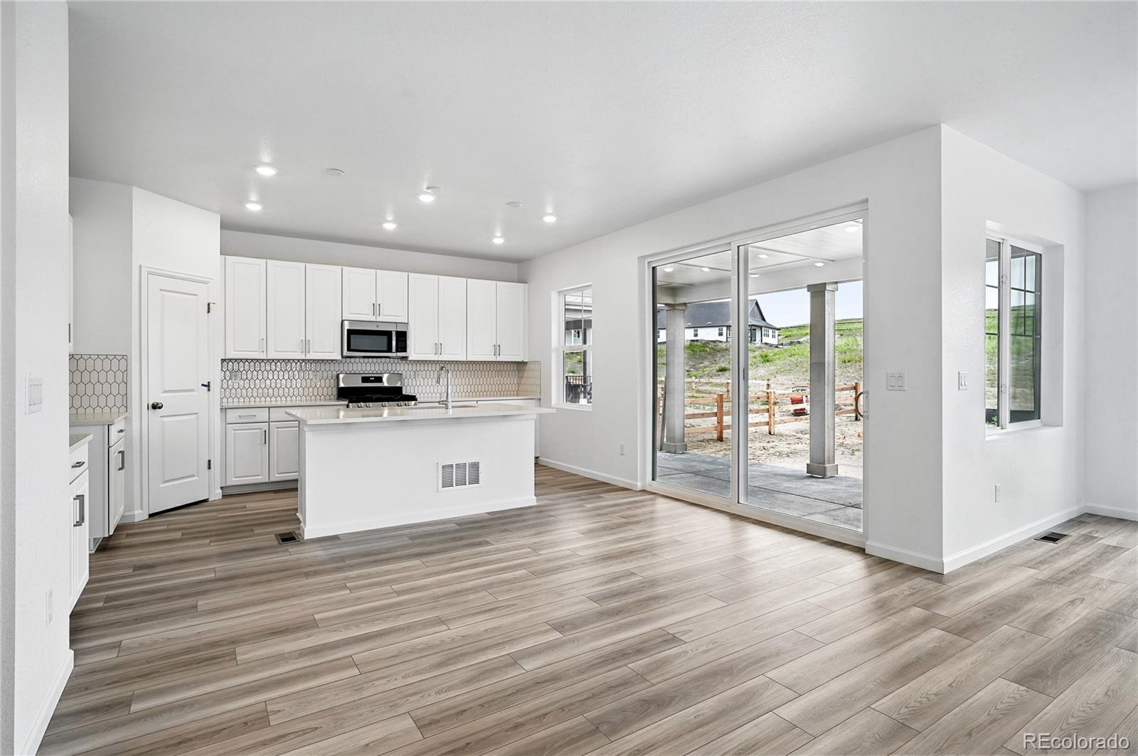 39713 Penn Road Elizabeth, CO 80107 - Photo 4 of 32 a view of kitchen with granite countertop refrigerator oven sink and white cabinets with wooden floor