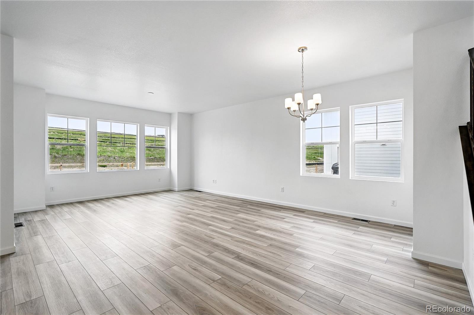 39713 Penn Road Elizabeth, CO 80107 - Photo 8 of 32 an empty room with wooden floor and windows