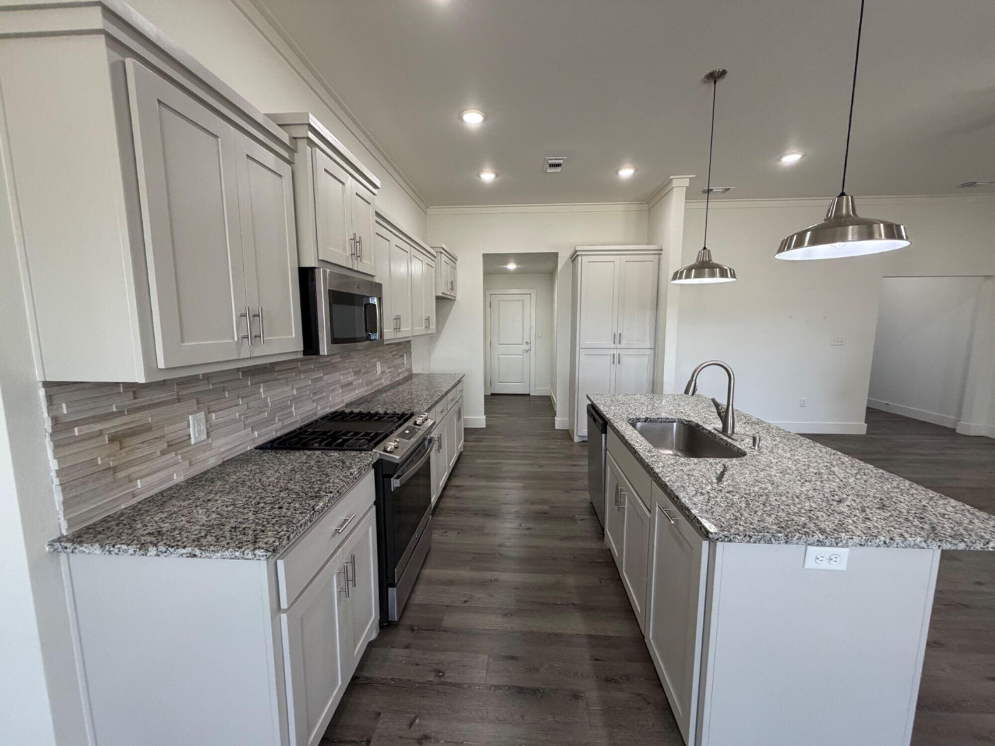 405 Ranger Street Wolfforth, TX 79382 - Photo 8 of 19 a kitchen with stainless steel appliances granite countertop a sink stove and refrigerator