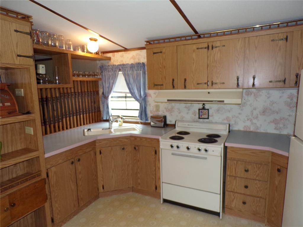 3239 Morrison Way Spring Hill, FL 34606 - Photo 7 of 17 a kitchen with a stove a sink and a microwave