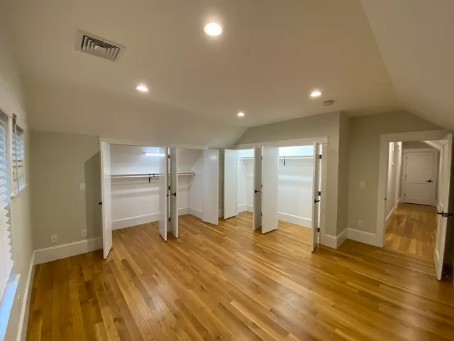 a view of empty room with window and wooden floor