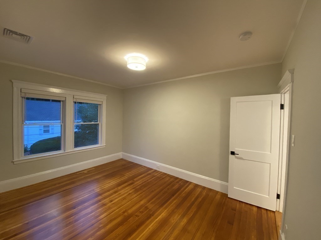 26 Playstead Road, Unit 2 Newton, MA 02458 - Photo 16 of 27 a view of an empty room with wooden floor and windows