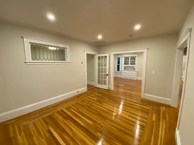 en empty room with wooden floor and windows