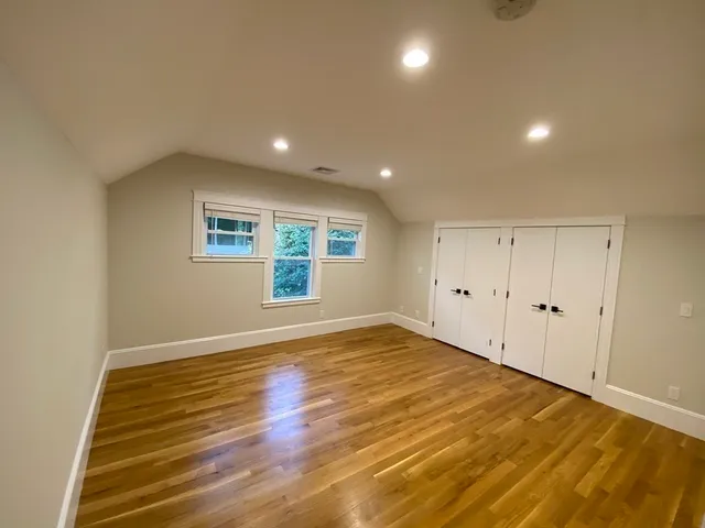 a view of empty room with wooden floor
