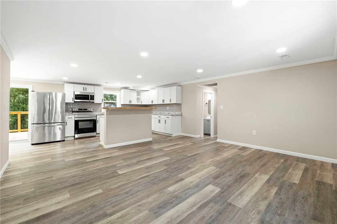 418 Old River Road Pelzer, SC 29669 - Photo 28 of 29 An open floorplan seamlessly connects the well-appointed kitchen to a generous living area, offering cohesive modern living.