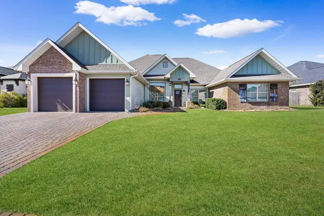 a front view of a house with a garden and yard