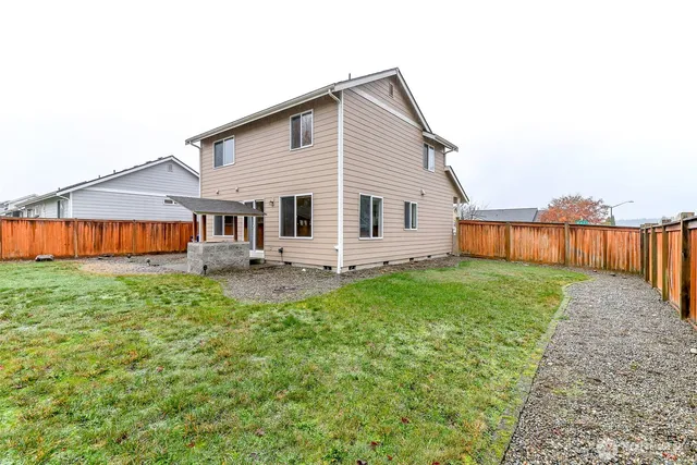 a view of a house with backyard and sitting area