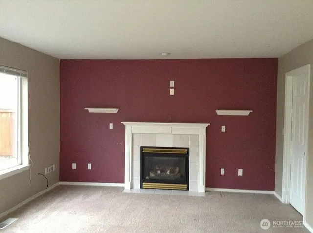 a view of a livingroom with a fireplace and window