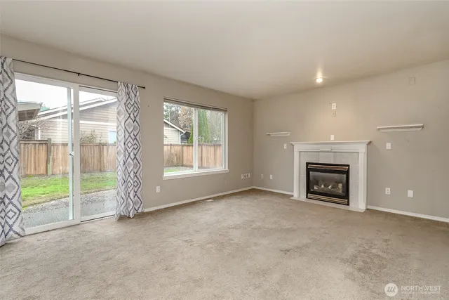 a view of an empty room with a fireplace and a window