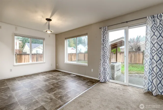 an empty room with windows and ceiling fan
