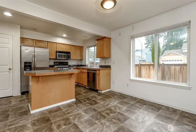 a kitchen with stainless steel appliances granite countertop a stove a sink and a refrigerator