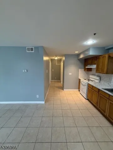 a large kitchen with a stove a sink and a refrigerator