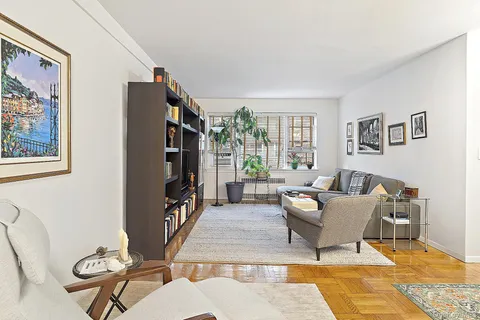 a living room with furniture a window and a flat screen tv