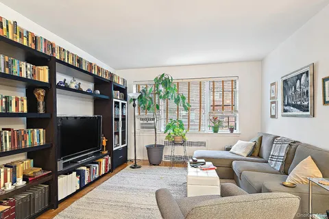 a living room with furniture a flat screen tv and a book shelf