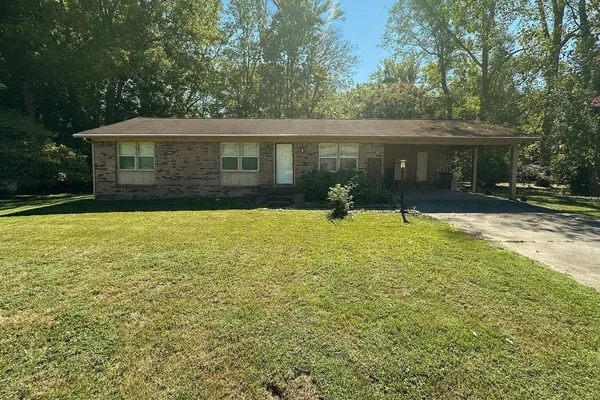 a front view of house with yard and trees