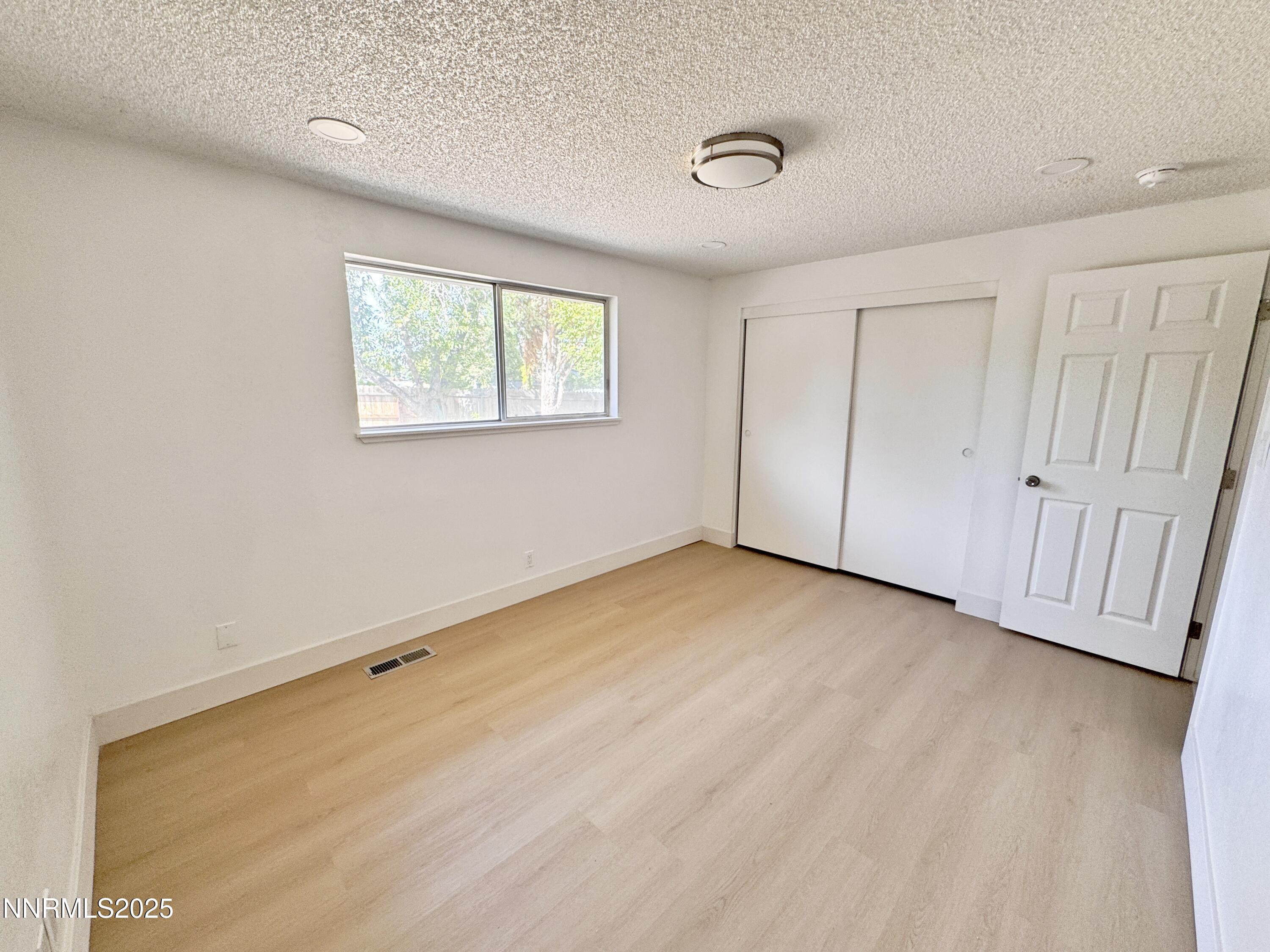 4205 Santa Maria Drive Reno, NV 89502 - Photo 12 of 23 an empty room with wooden floor and windows